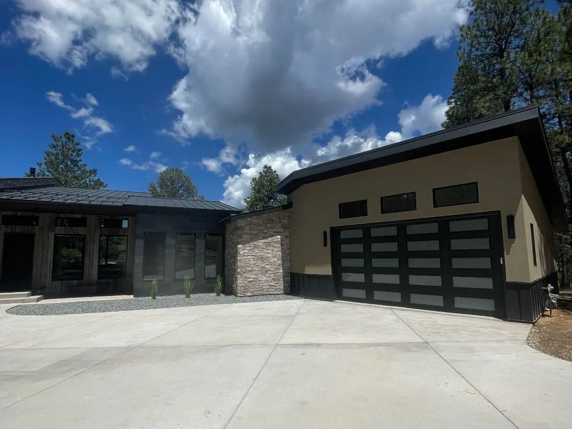Matte black smooth-panel garage door on a modern Montana home